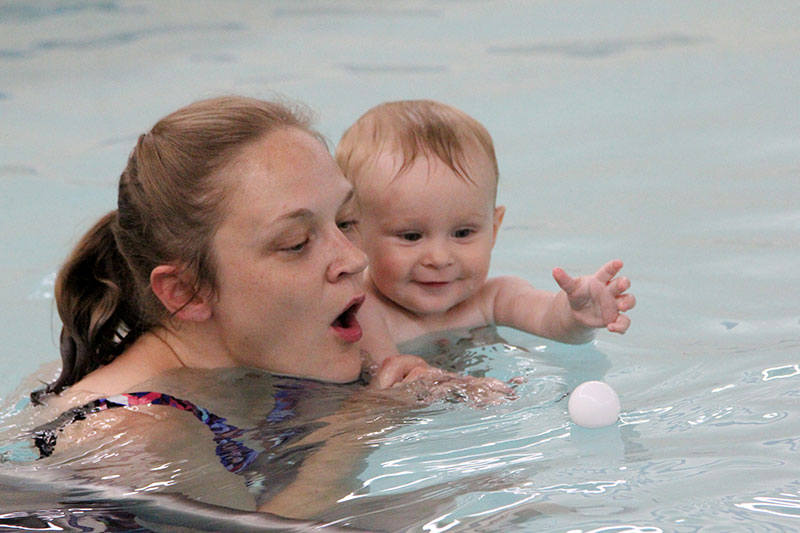 Swimmer with baby in the pool